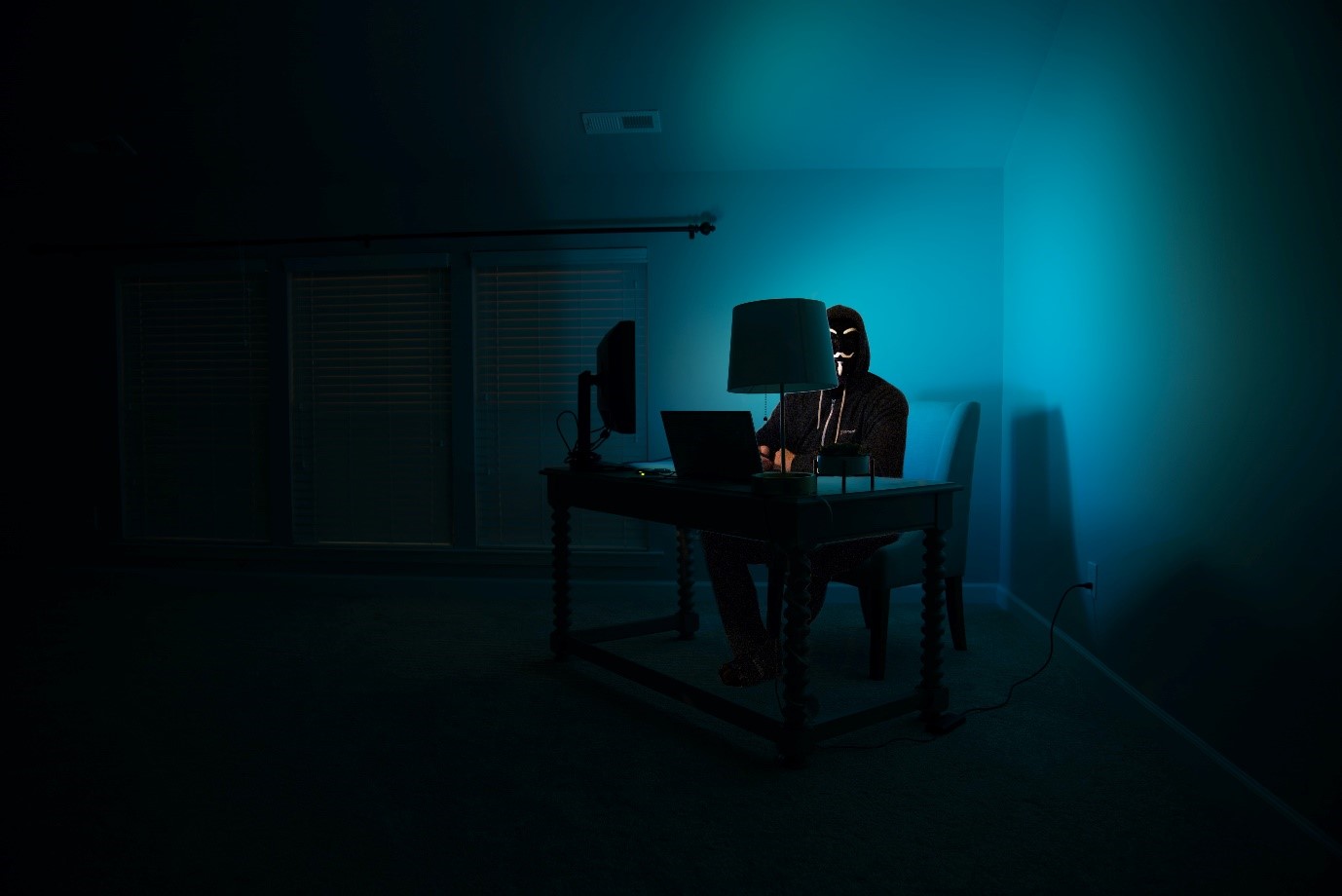 in a dark room with person sitting behind the computer